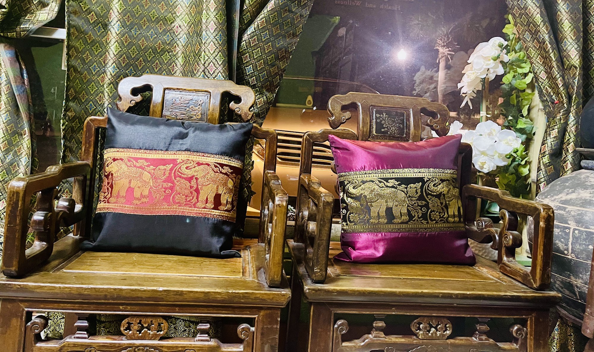 Carved wooden chairs with silk elephant cushions