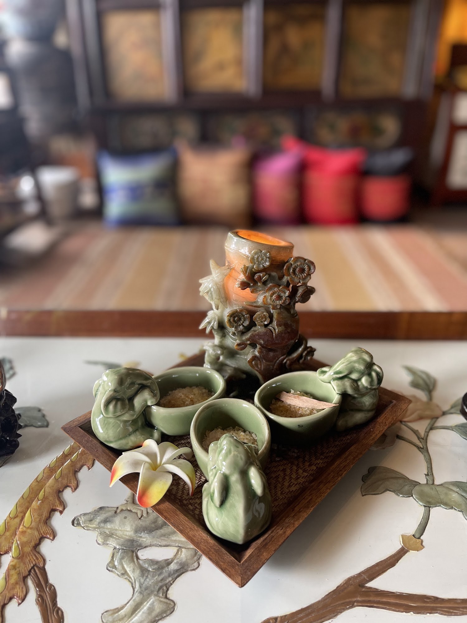 Jade aroma burner with elephant dishes and a plumeria flower